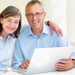 Happy old couple using laptop Planning as a family - funeral planning can be done with love and honor