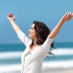Pretty young woman with arms raised It