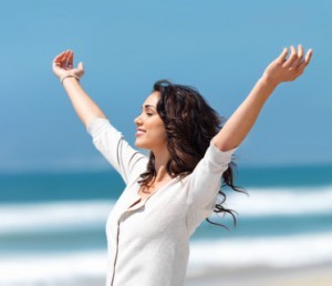 Pretty young woman with arms raised It's uplifting to remember your happiness!
